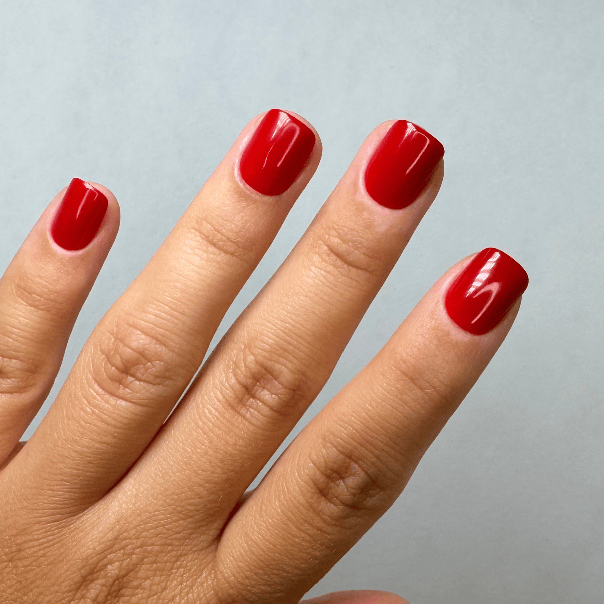 Classy Red Extra Short Square Press-On Nails an der Hand getragen