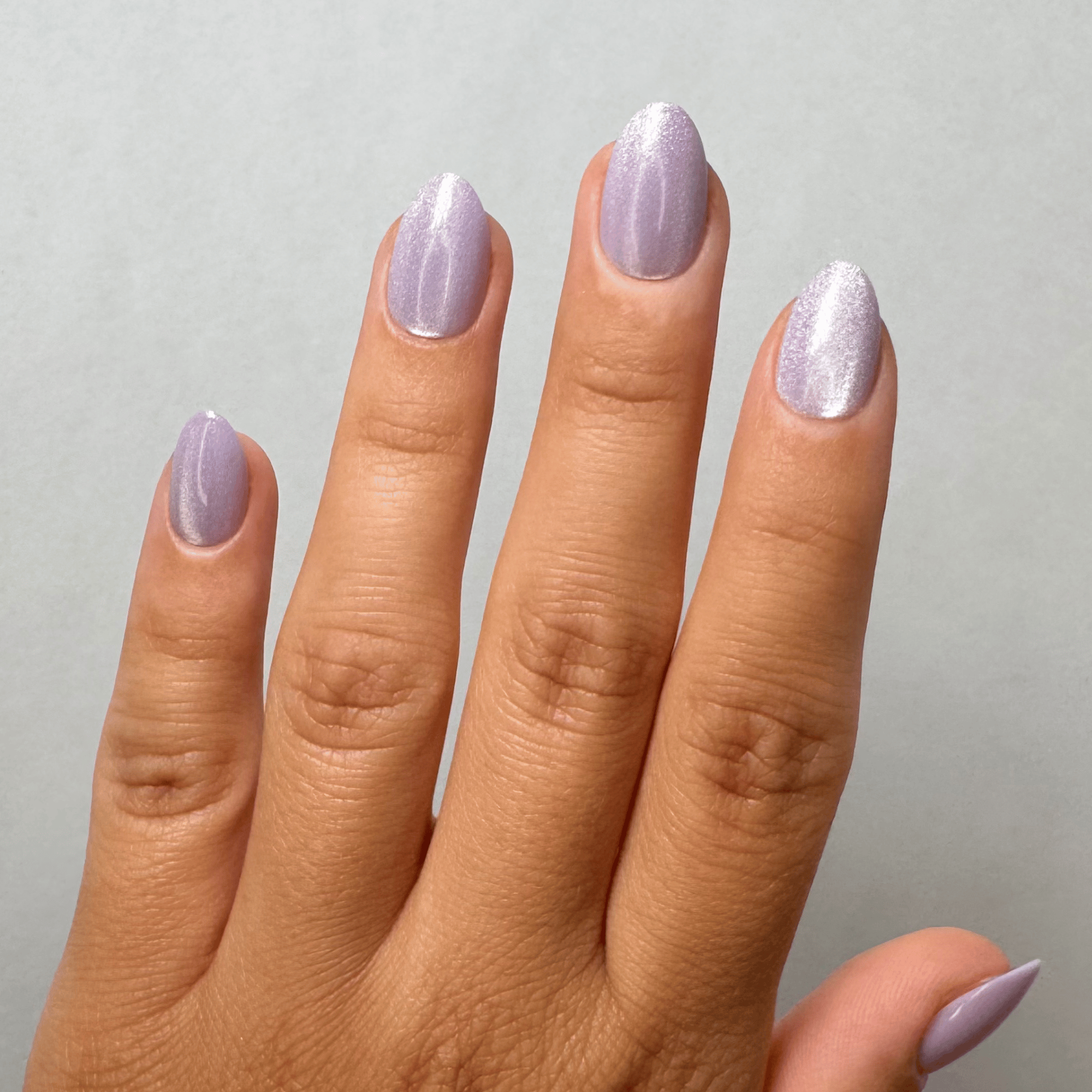 Lavender Cateye Short Almond Press-On Nails an der Hand getragen