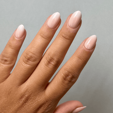 Creamy Babyboomer Short Almond Press-On Nails an der Hand getragen