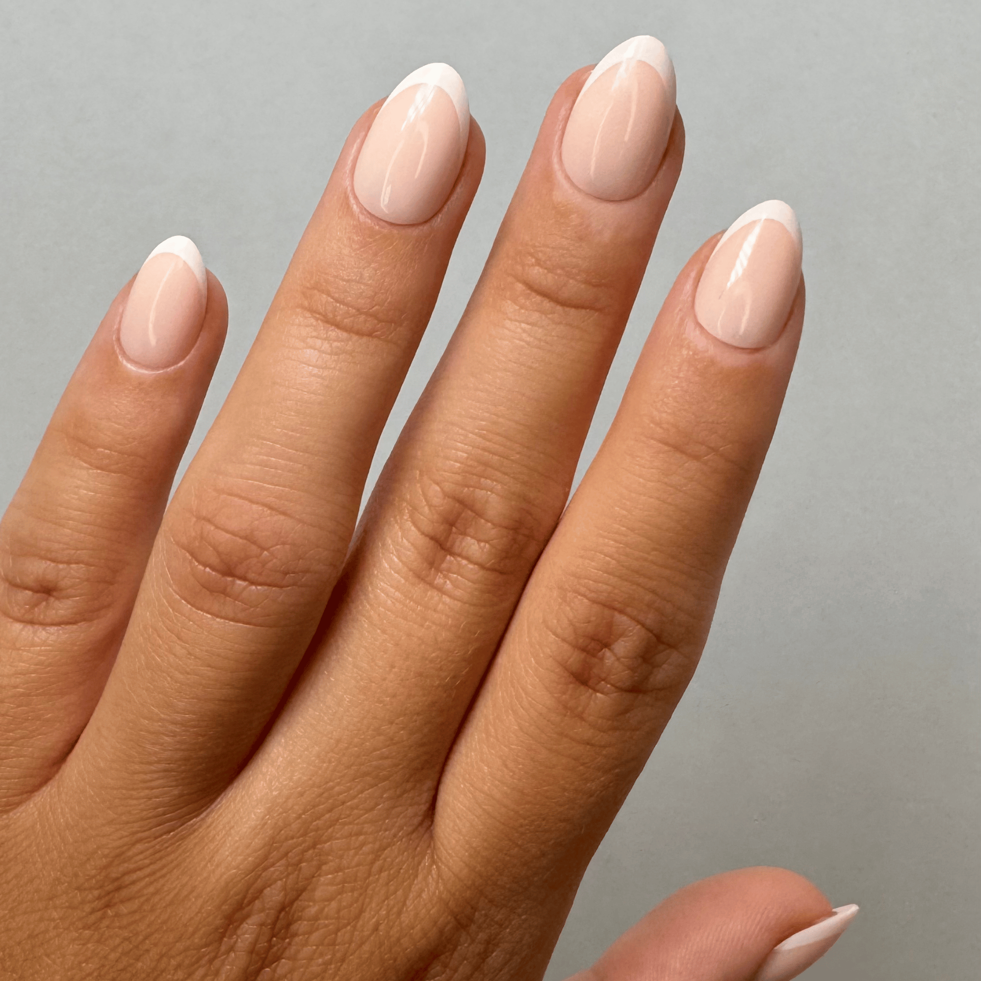Classy French Short Almond Press-On Nails an der Hand getragen