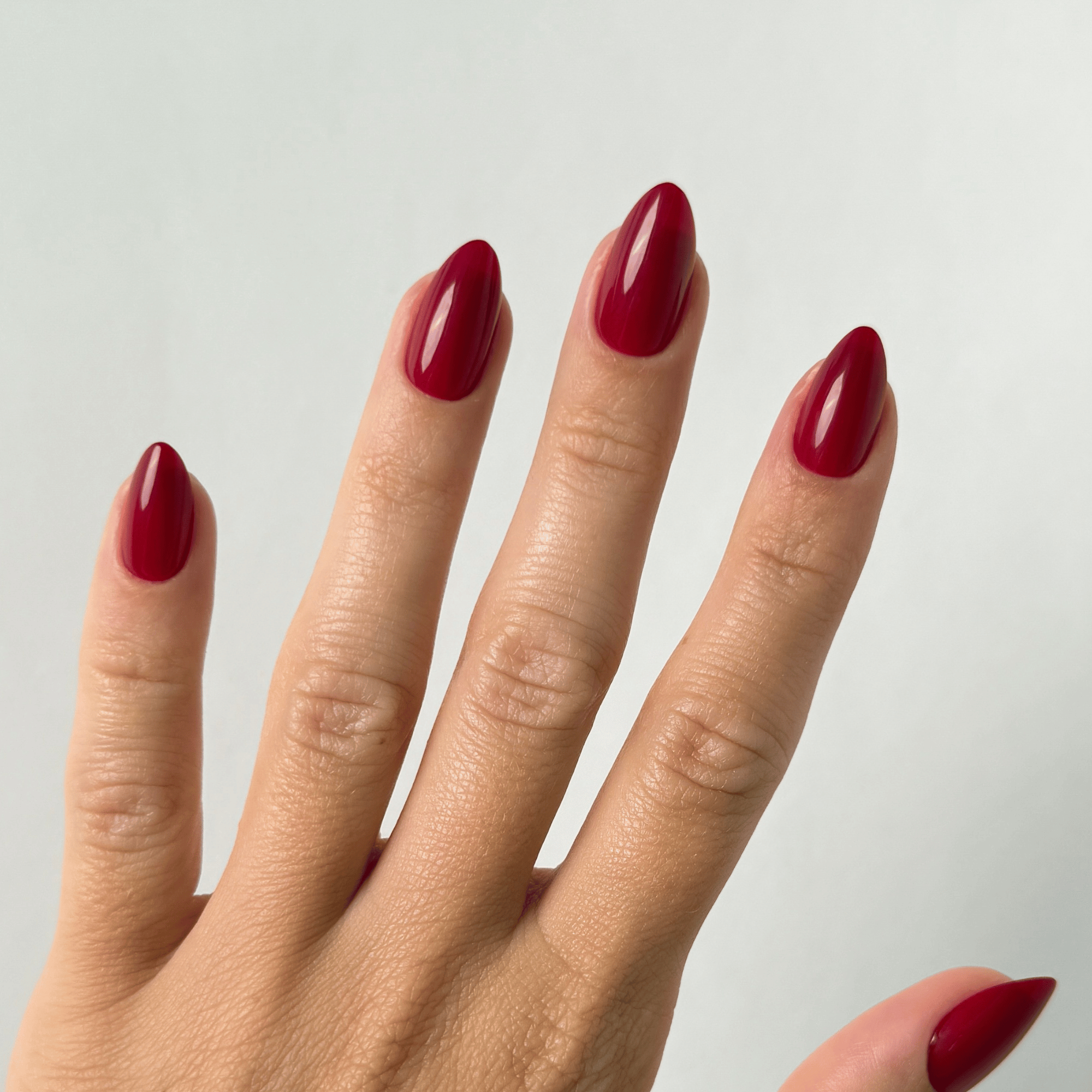 Berry Cherry Medium Almond Press-On Nails an der Hand getragen